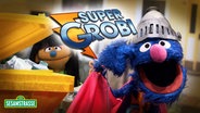 Links steht ein Puppen Mädchen vor einer gelben Mülltonne rechts Super-Grobi mit Helm und Supermann Umhang.In der Mitte steht die Schrift Super-Grobi © NDR 